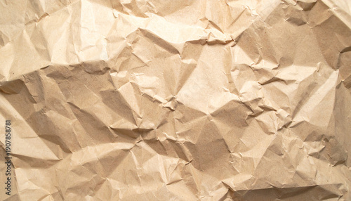 A detailed close-up view of the textured surface of crumpled brown kraft paper, showing numerous folds and creases.