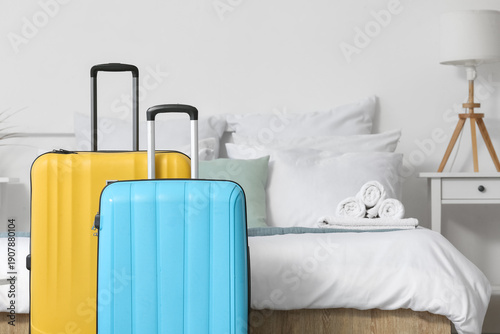Suitcases near bed in light...