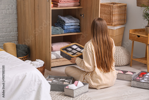 Young woman folding clean c...