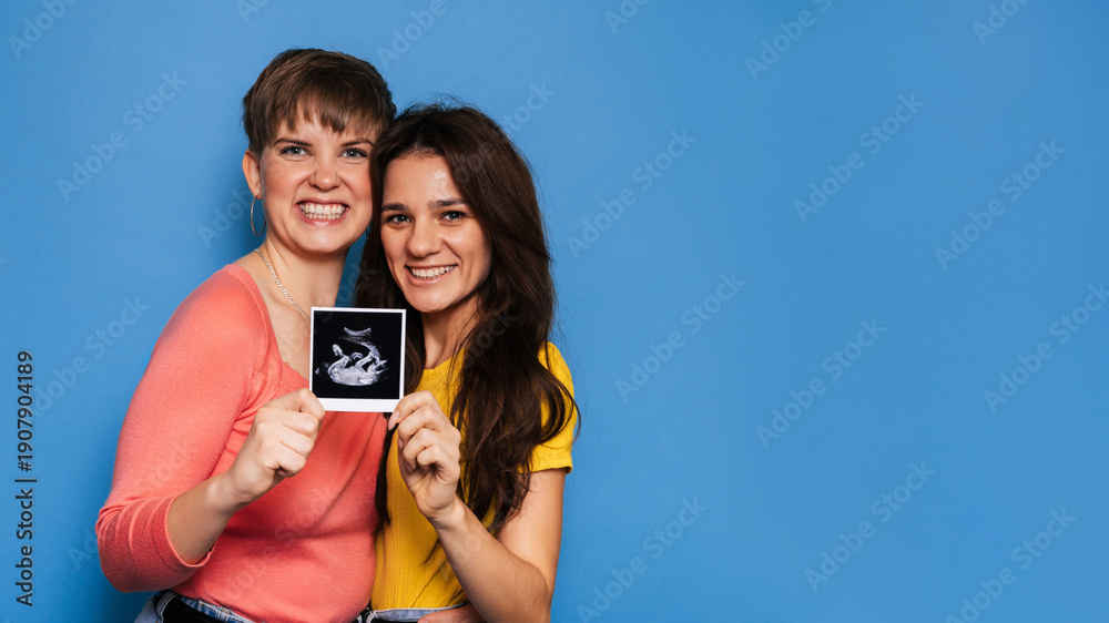 custom made wallpaper toronto digitaltwo women presenting a baby scan toward the camera. Copy space