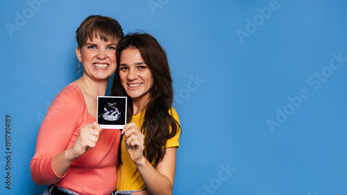 Wallpaper Mural two women presenting a baby scan toward the camera. Copy space Torontodigital.ca