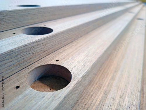 Milled holes in veneered panels for furniture hinges. Close-up. Illustration. Technological process.