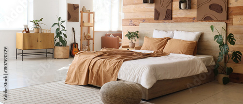 Schilderij op canvas Interior of stylish bedroom with comfortable bed, pouf and houseplants