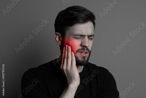 Young caucasian male experiencing toothache with facial pain expression