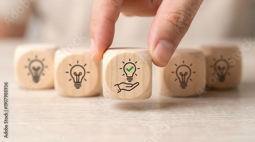 Innovation concept with hand placing a wooden block with a green light bulb