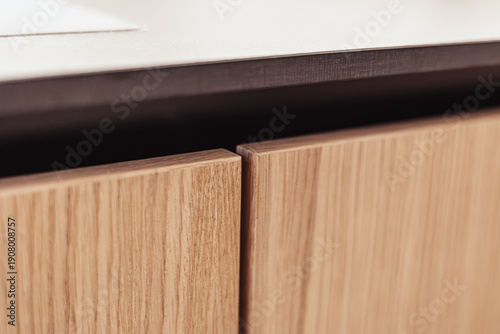 Photos Detail view of two aligned handleless wood cabinet doors with vertical grain, se
