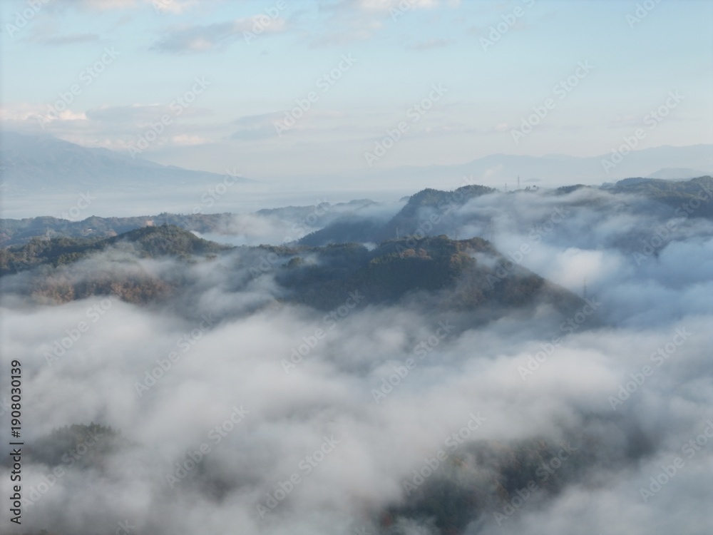 Obraz premium The sky is cloudy and the mountains are covered in fog. The clouds are low and the mountains are in the background