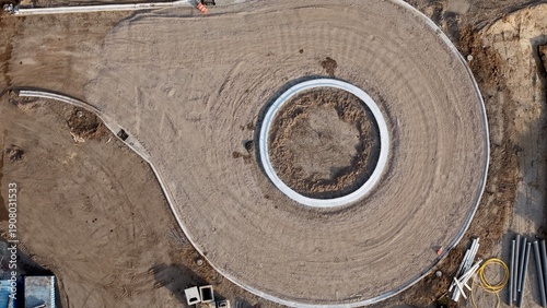 Aerial view of a newly constructed roundabout, its circular form stark against the brown earth, framed by bright concrete, Jacksonville, Florida, United States.