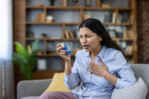 Tableau sur toile Young woman on a sofa experiencing an asthma attack, struggling to breathe and c