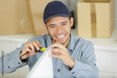 Tableau sur toile a male builder fixing a cupboard