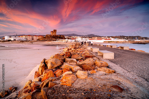 Foto Picturesque color of the sky on coast Spain, promenade with people in Tarifa at sunset