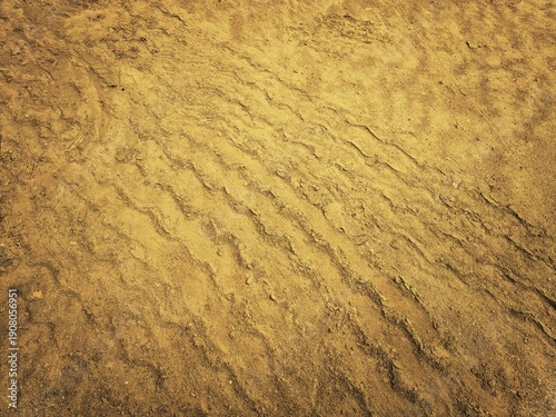 Obraz na płótnie ​Dry sandy soil texture with heavy machinery tire tracks and industrial earthwork patterns