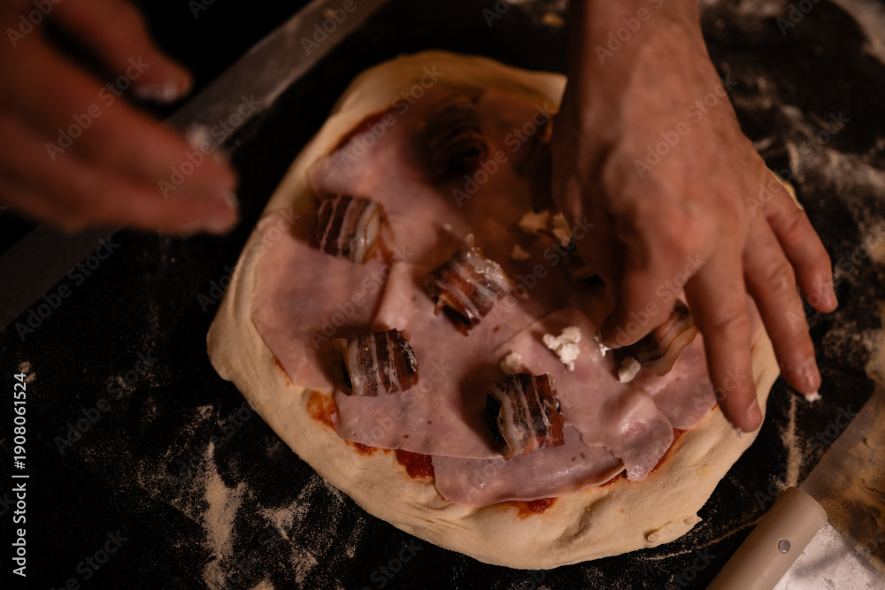 Obraz premium Chef hands preparing homemade pizza with bacon and ham