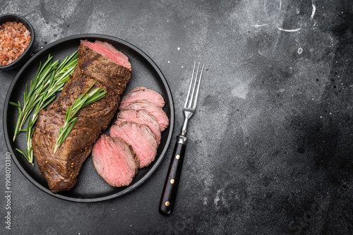 Fotografie Medium rare roast beef cooked whole and sliced with rosemary