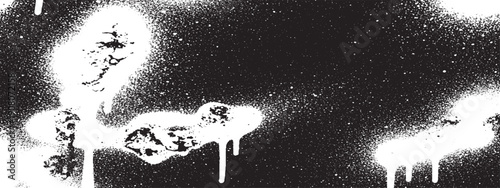 Abstract Black and White Spray Paint Drips and Splatters on a Dark Surface.