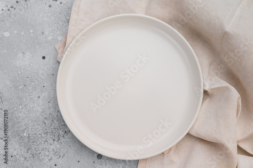 Canvastavla Empty white ceramic plate on gray concrete background with linen cloth