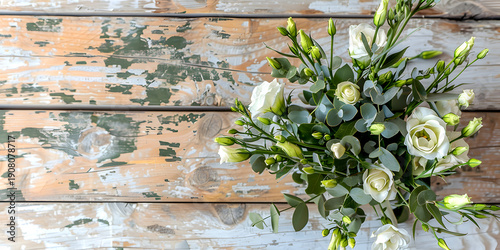 White roses and green buds arranged in a bouquet on a rustic wooden table with a weathered finish, showcasing natural textures and colors
