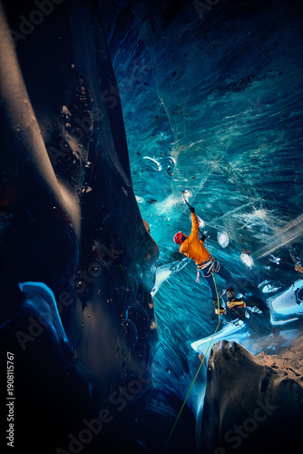 Man climbing frozen ice cave in winter mountains