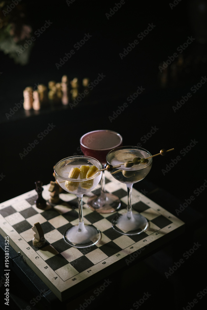 custom made wallpaper toronto digitalThree Martini cocktails, two differently garnished dirty martinis and a twist on espresso martini, standing on a wooden chess board in the dark room, close up view 