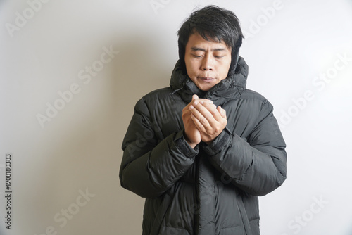 Adult Man in Warm Winter Coat with Hands Together Trying to Keep Warm
