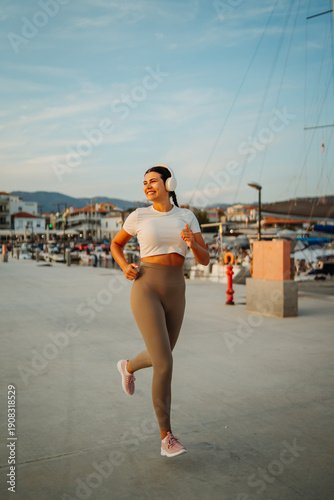 Woman jogging in headphones enjoying harbor workout