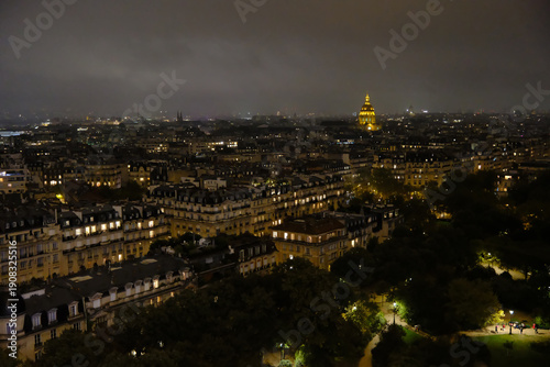 Photography High-angle night view of Paris cityscape featuring the illuminated golden dome o