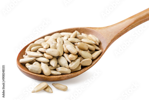 Sunflower kernels in a wooden spoon on a white background. Isolated