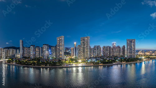 Wallpaper Mural Modern residential skyscrapers illuminated at night along a riverbank under a deep blue sky. Torontodigital.ca