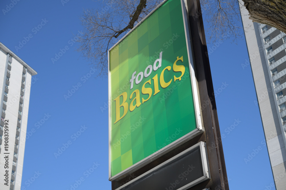 Fototapeta premium road pylon sign outside Food Basics, a discount supermarket chain, located here at 238 Wellesley St E, Toronto