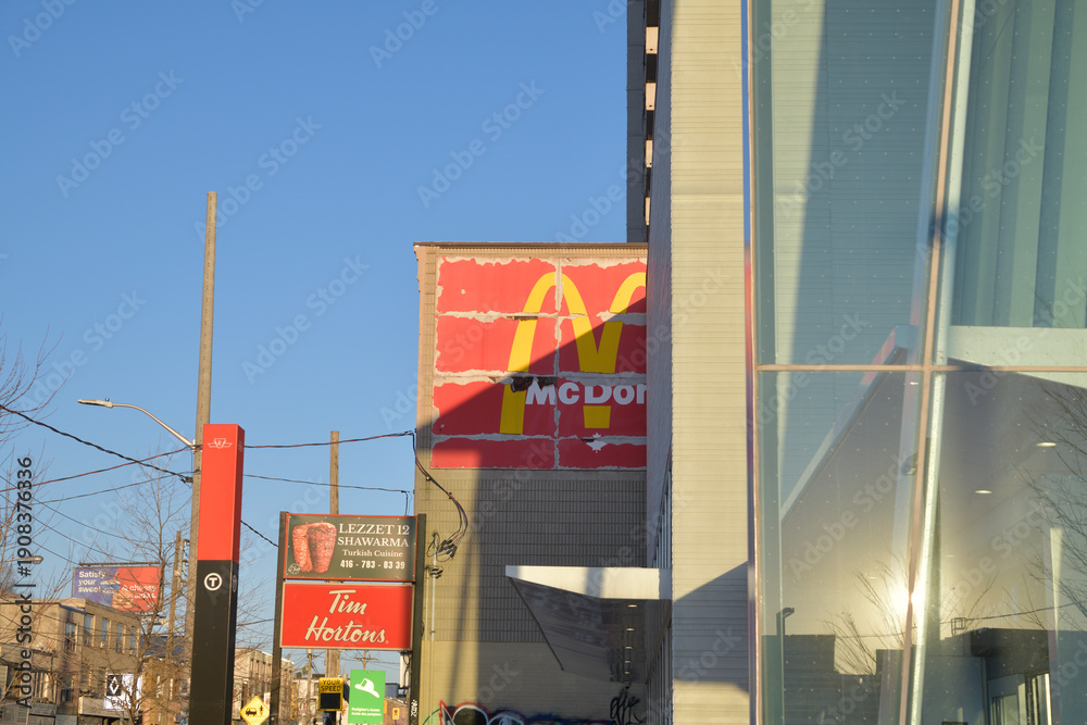 Fototapeta premium looking east on Eglinton Av outside Fairbank station of Line 5, with McDonald's ghost sign, incl Tim Hortons, southeast corner at Dufferin St, Toronto
