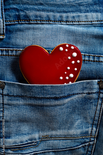 A close-up of a red heart-shaped gingerbread cookie in the back pocket of jeans.
Valentine's Day