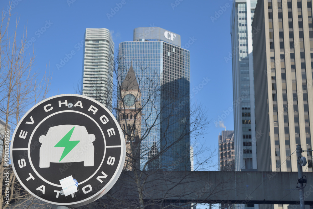 Naklejka premium EV Charge Station with defocused view of historic and contemporary buildings, Toronto (Flo Charging Station), 100 Queen St W, Nathan Phillips Square