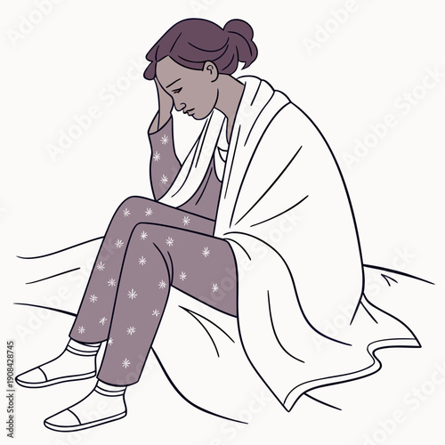 Woman sitting on bed feeling unwell covered in blanket