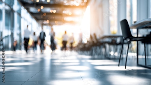 Blurred figures navigating a brightly lit modern office corridor during day