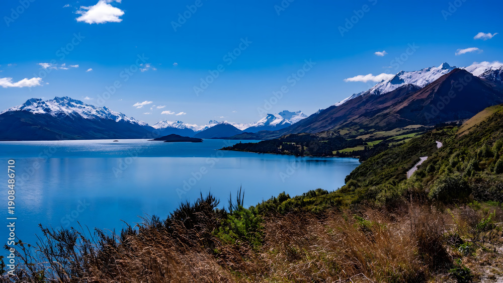 Fototapeta premium Alpine Lake with Snow-Capped Mountains and Wilderness