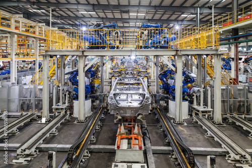 Foto Robotic Welding Arm Assembly Line in Automobile Factory Production