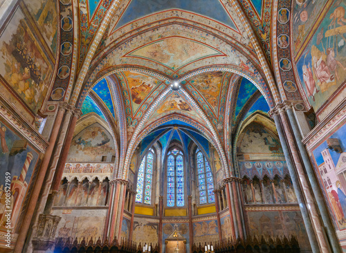 Assisi's Upper Basilica transept, featuring Cimabue's frescoes, starry Gothic vaults, and 13th-century stained glass windows. A vibrant masterpiece of medieval Italian art