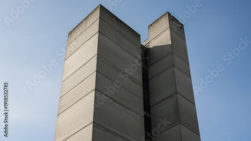 Brutalist architecture building with concrete facade reaching into clear blue sky