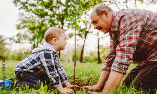 Obraz na płótnie A grandfather and his grandson playfully touch noses while sitting in a park