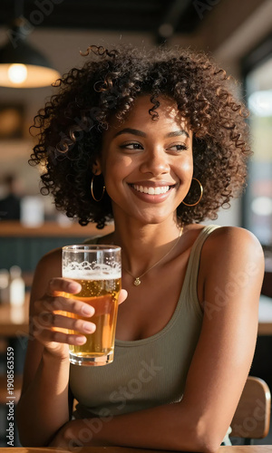 portrait african american woman curly hair smiling holding glass beer sunlit interior space warm