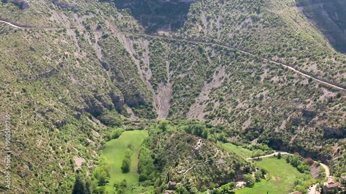 Quelques maisons éparpillées le long de la rivière, au fond du canyon, près d'un méandre asséché. Navacelles, Hérault, France.
