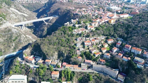 A modern highway viaduct spans the dramatic Rjecina River canyon in Croatia, connecting towns amidst rugged hills under a dynamic cloudy sky.