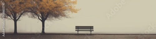 A serene foggy landscape featuring a lone bench surrounded by bare trees and soft autumn leaves.