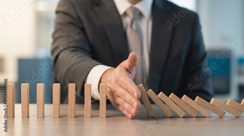 high quality, detailed photograph, business person in suit, hands stopping domino pieces from falling, conceptual image