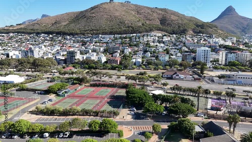Drone flies over tennis courts in Green Point toward Signal Hill on a sunny day in Cape Town, South Africa