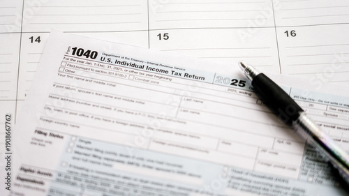 Form 1040 for us individual income tax return for the year 2025, with a pen resting on a calendar page