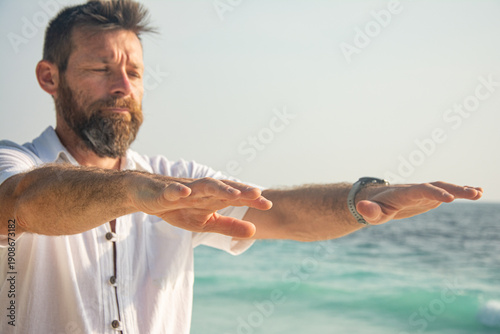 Man Practicing Qigong Energy Exercise on Beach