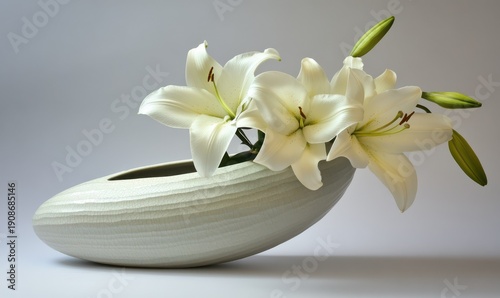 Elegant white lily arrangement in a sleek ceramic vase, soft natural light highlighting its delicate petals and creating a serene floral focus