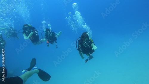 Antalya , Turkey - 08.19.2025 -  A captivating underwater scene featuring multiple scuba divers navigating through vibrant corals and marine life in a clear blue ocean, oc01