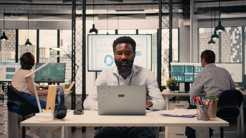 Fotografía Black professional reviewing resource allocation and performance metrics on laptop
